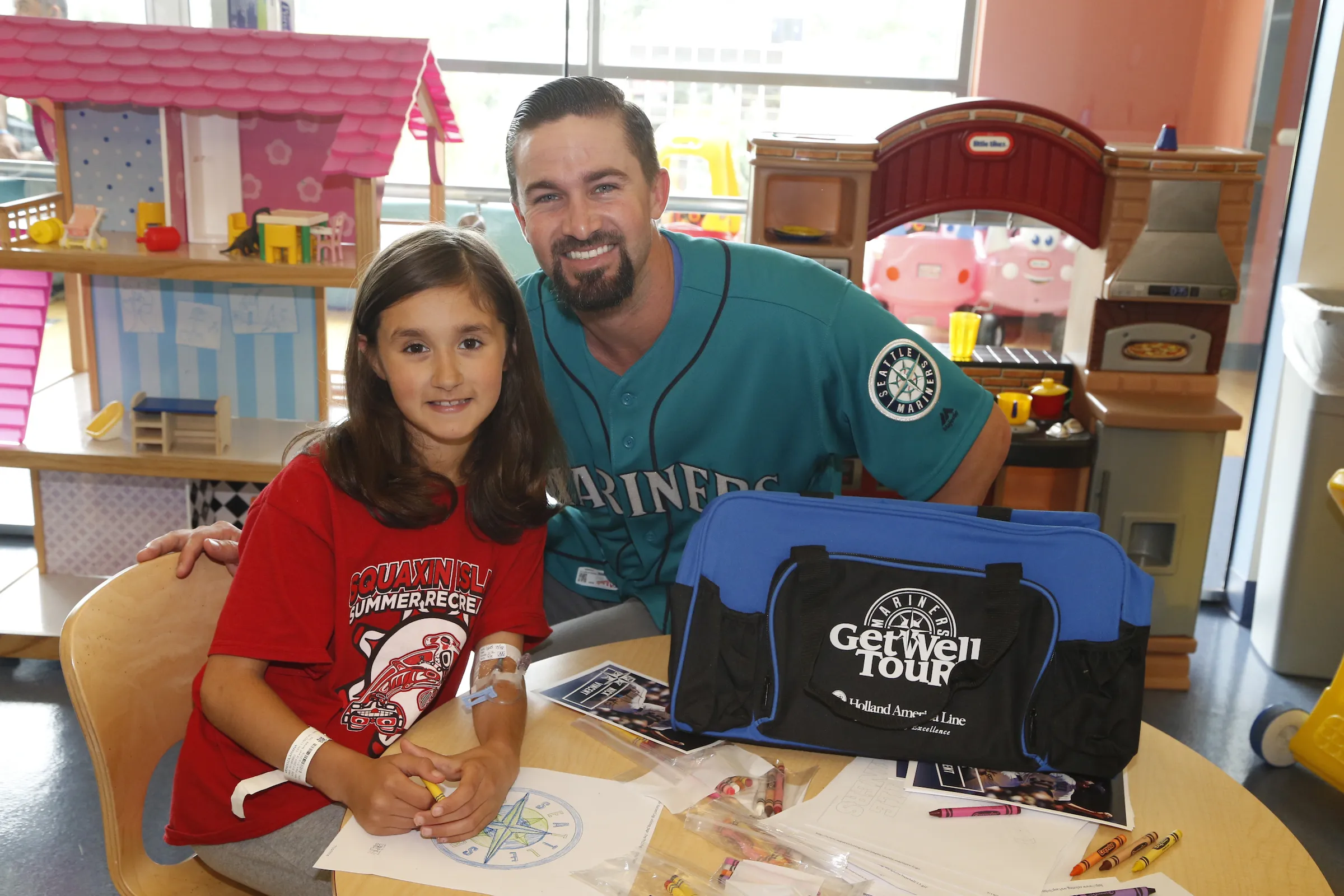 A Seattle Mariners player visits and colors with a young patient during a hospital Get Well Tour